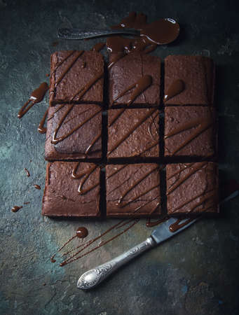 Brownie cake dessert. Dark sponge cake with cocoa and chocolate on a old textural table.