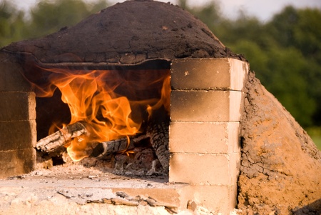 Fire burning in earthen ovenの写真素材