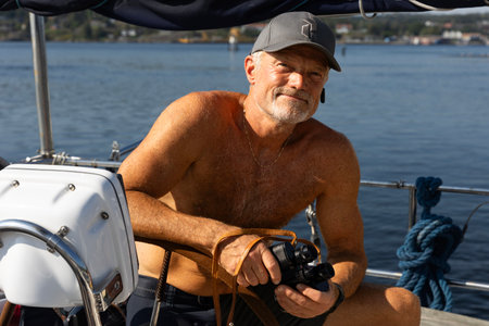 A man enjoying his time on a boat while capturing moments with his camera in hand