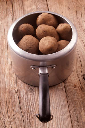 some potatoes in an old aluminum potの写真素材