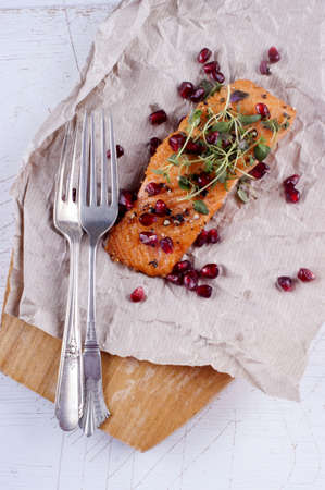 grilled salmon with pomegranate seed on brown paperの写真素材