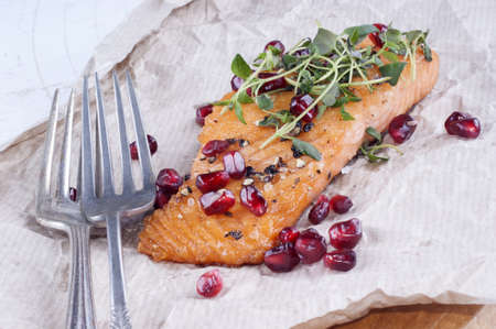 grilled salmon with pomegranate seed on brown paperの写真素材