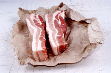raw fat pork belly on brown paperの写真素材