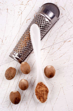 grated nutmeg and nutmeg powder on a white spoonの写真素材