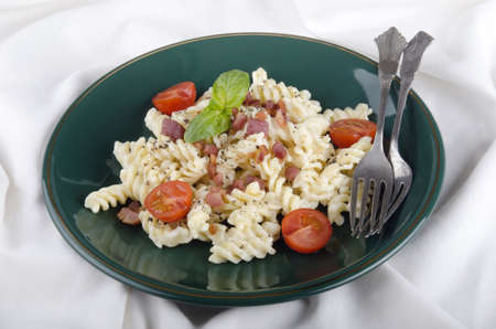 pasta with white cream cheese sauce, italian pancetta, basil and tomatoの写真素材
