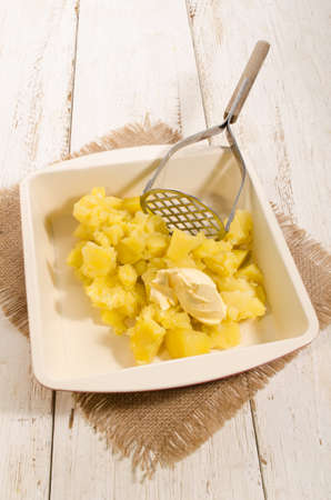 cooked potato cubes and butter to make mashed potatoesの写真素材