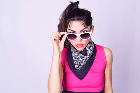 Portrait of fashionable young woman wearing stylish urban clothes. Fashion studio portrait over grey backgroung.の写真素材