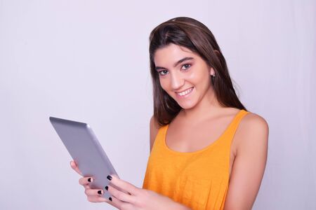 Tablet computer. Young woman holding tablet computer isolated on grey background. Casual caucasian beautiful woman.の写真素材