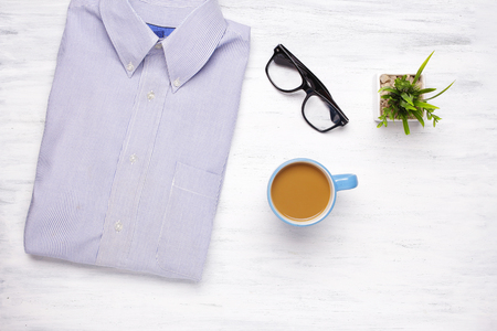 Businessman shirt, cup of coffee and hipster glasses on white wooden background. Business and office concept. Lifestyle.の写真素材