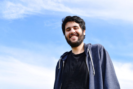 Portrait of young latin man in a park. Hispanic man smiling.の写真素材