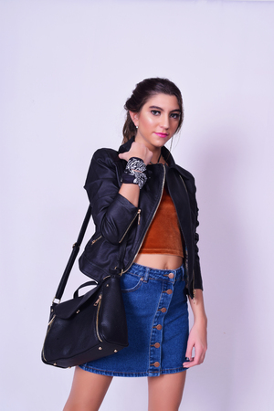 Portrait of fashionable young woman wearing stylish urban clothes. Fashion studio portrait over grey backgroung.の写真素材