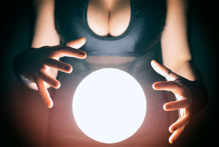 Attractive fortune teller predicting future omens with a mystical floating crystal ballの写真素材