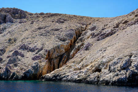 Small beach on St. Grgur, a small croatian island with harsh, but beautiful cliffs. The rocks have cracked by the constant heating of the sun.の写真素材