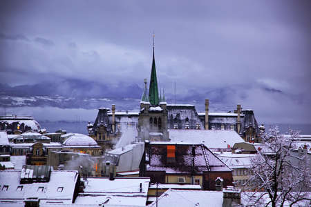 Winter evening in Lausanne.Skyline of Lausanne, Switzerland as seen from the Cathedral at sunset zoomed-in on the tower of St-Francois Church.の写真素材