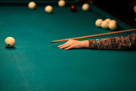Playing billiard. Billiards balls and cue on green billiards table. Billiard sport concept. Pool billiard game. Russian pyramid (Russian billiard, pyramid billiards), cue sport.の写真素材