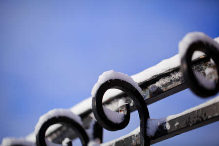 Iron railing covered with morning frost. Snow and ice texture.