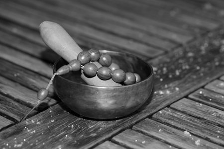 Tibetan singing bowl on a wooden table. black and white photo - Imageの写真素材