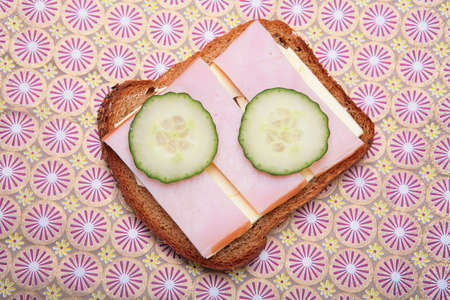 sandwich from pumpernickel bread with butter, ham and cucumberの写真素材