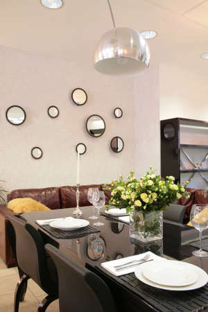 interior of modern dinning-room  with served table and bouquet of the tea roses