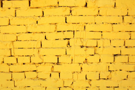 background, texture, aging wall from brick dyed yellow colorの写真素材