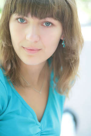 close-up portrait of the smiling green-eyed girl in blue t-shirt