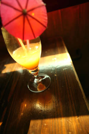 Goblet with Luminous Yellow Drink on Edge of the Tableの写真素材
