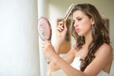 beautiful girl combs luxurious dark hairs, does hairstyle, horizontal portraitの写真素材