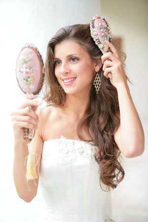 smiling beautiful girl does combs hair old-time combの写真素材