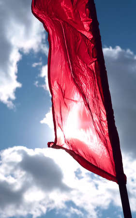 brightly red flag on winds, spring cool skyの写真素材