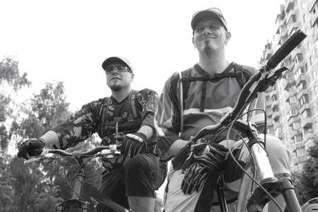 two serious bicyclists look onward, monochromeの写真素材