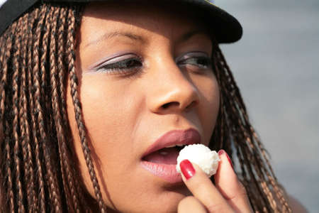 close-up portrait of the attractive girl, eating sweetmeatの写真素材
