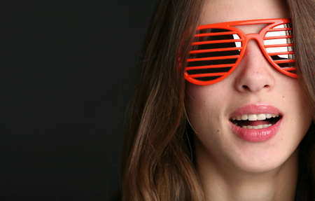 portrait of the attractive smiling woman in the red sunglasses with copy-spaceの写真素材