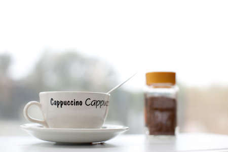 a cup of cappuccino and coffee bottle with copy-space, small depth sharpnessの写真素材