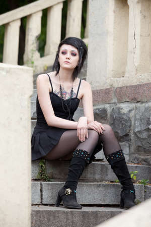 young brunette girl in gothic style on the old stepsの写真素材