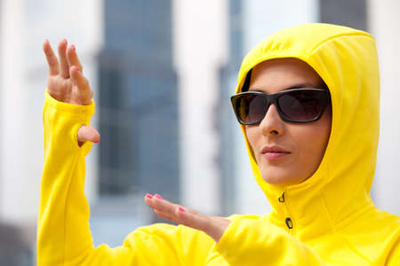 extravagant girl in yellow hood and sunglasses