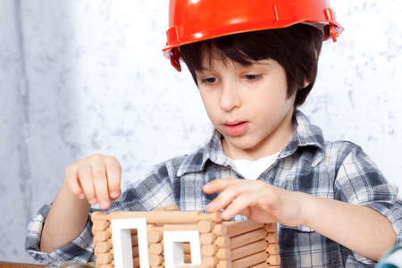 boy builder in red helmet tape built a new homeの写真素材