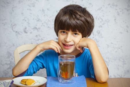 smiling boy with tea and biscuitsの写真素材
