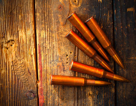 five rifle cartridges on old wooden surfacefive rifle cartridges on vintage wooden surfaceの写真素材