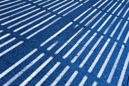 background, strips of blue shadow on granite slabsの写真素材