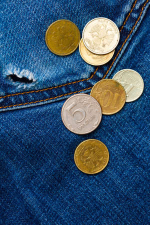 jeans pocket with hole and coins, close up