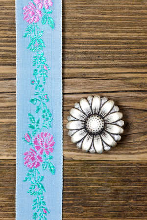 still life, vintage aqua color tape with embroidered ornaments and old button flower
