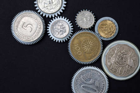 Coins gears on a black background. business conceptの写真素材