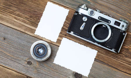 retro photo mock up, vintage camera and lens on old wooden background. still life with copy space
