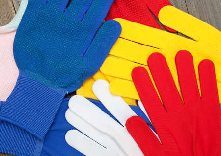 colored construction gloves on an old workbench. copy spaceの写真素材