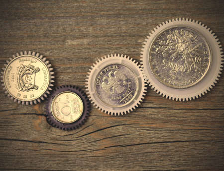coins as a gears on textured wooden surface.  image filter retro styleの写真素材