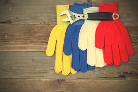 workers gloves and wrench on textured wooden surface of a old work bench.  image filter retro styleの写真素材