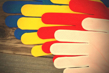 colorful set of working gloves on an old wooden surface.  image filter retro styleの写真素材