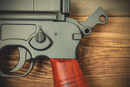 fragment of an old Mauser machine pistol with a fuse and trigger.  image filter retro styleの写真素材