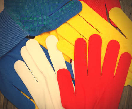 set of four colored construction gloves on an old workbench. copy space.  image filter retro styleの写真素材