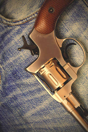 Nagan revolver on blue jeans background, close-up, part of.  image filter retro styleの写真素材